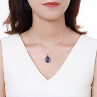 Close up detail of KHAISTA blue pear crystal pendant necklace