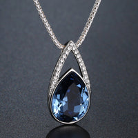 Side angle view of KHAISTA blue pear crystal pendant necklace