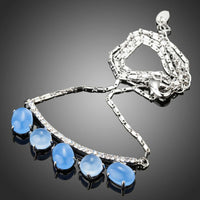 Side angle view of KHAISTA blue resin Austrian crystal pendant necklace