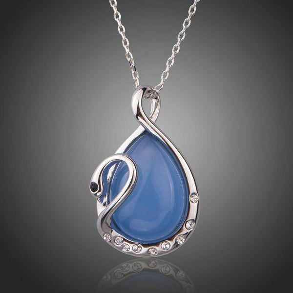 KHAISTA blue crystal swan pendant necklace on white background