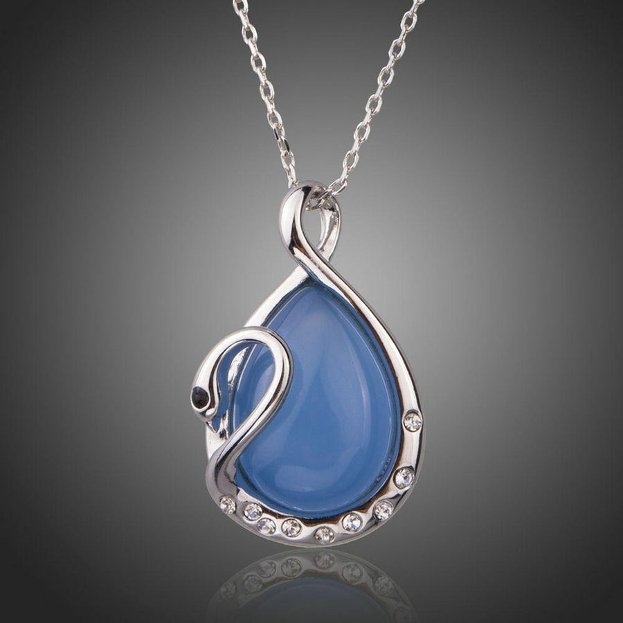 KHAISTA blue crystal swan pendant necklace on white background