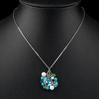 Close up detail of KHAISTA blue teardrop Stellux Austrian crystal necklace