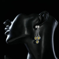 Side angle view of KHAISTA bow knot crystal drop hoop earrings