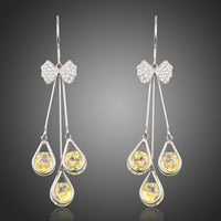 KHAISTA bow knot crystal drop hoop earrings on white background