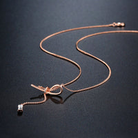 Close up detail of KHAISTA crystal bow knot pendant necklace