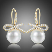 KHAISTA pearl bow knot dangle drop earrings on white background