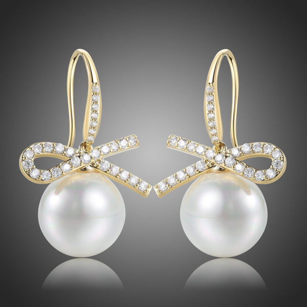 KHAISTA pearl bow knot dangle drop earrings on white background