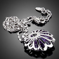 Side angle view of KHAISTA white gold bud Stellux crystal necklace