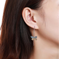 Close up of KHAISTA crystal butterfly drop earrings