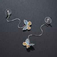 Side angle view of KHAISTA crystal butterfly drop earrings