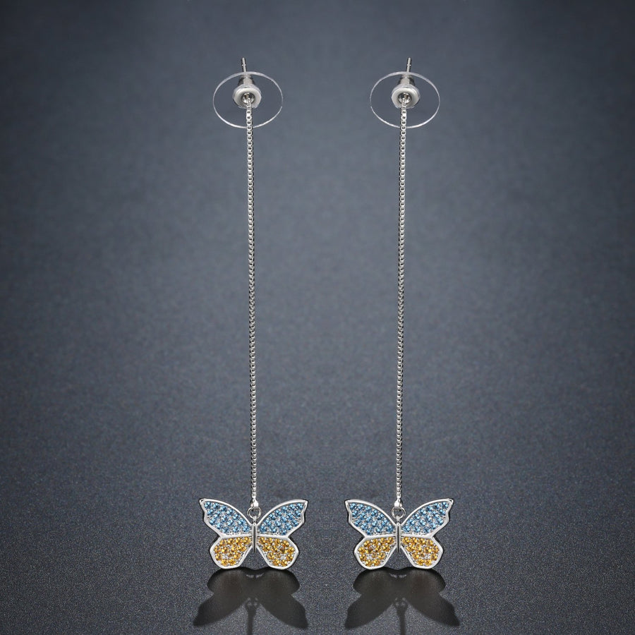 KHAISTA crystal butterfly drop earrings on white background