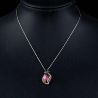 Side angle view of KHAISTA butterfly on autumn leaf crystal pendant necklace