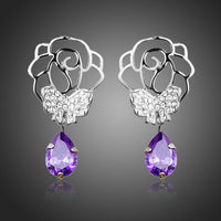 KHAISTA butterfly on flower crystal drop earrings on white background