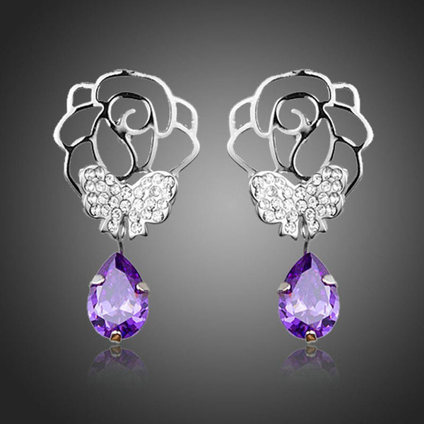 KHAISTA butterfly on flower crystal drop earrings on white background