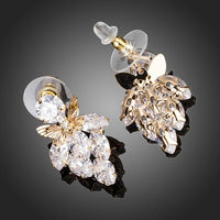 Close up of KHAISTA butterfly on leaf crystal drop earrings
