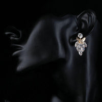 Side angle view of KHAISTA butterfly on leaf crystal drop earrings
