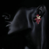Side angle view of KHAISTA crystal butterfly raspberry drop earrings