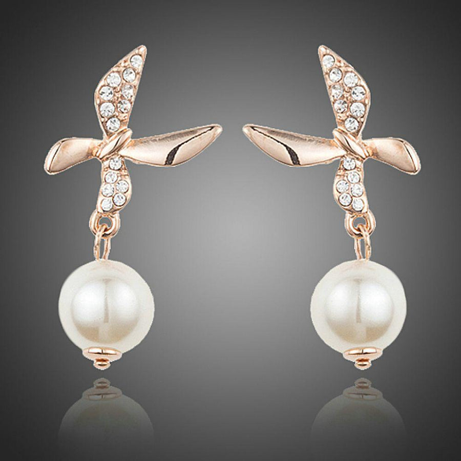 KHAISTA butterfly pearl drop earrings on white background