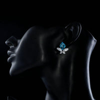 Side angle view of KHAISTA sea blue crystal butterfly stud earrings