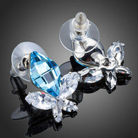 Close up of KHAISTA sea blue crystal butterfly stud earrings
