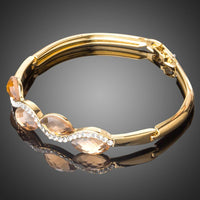 Close up detail of KHAISTA caramel crystal wave bangle