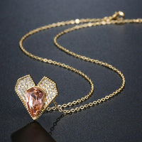 Side angle view of KHAISTA champagne Austrian crystal vintage heart necklace