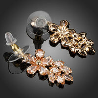 Side angle view of KHAISTA champagne crystal cluster drop earrings