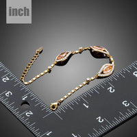 Side angle view of KHAISTA champagne cubic zirconia bracelet