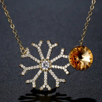 Close up detail of KHAISTA champagne CZ snowflake pendant necklace