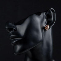 Side angle view of KHAISTA champagne CZ stud earrings