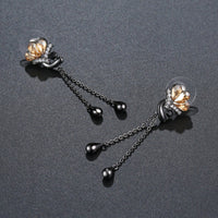 Side angle view of KHAISTA champagne crystal flower drop earrings