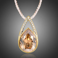KHAISTA champagne pear shape crystal necklace on white background