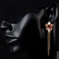 Close up of KHAISTA champagne sunflower crystal drop earrings
