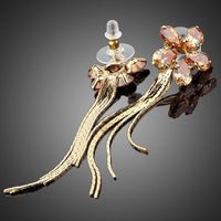 Side angle view of KHAISTA champagne sunflower crystal drop earrings