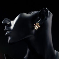 Side angle view of KHAISTA chocolate pearl crown stud earrings