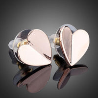 Side angle view of KHAISTA classic gold heart stud earrings