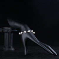 Side angle view of KHAISTA classic milk white crystal pearl bracelet