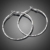 Side angle view of KHAISTA classic round crystal hoop earrings