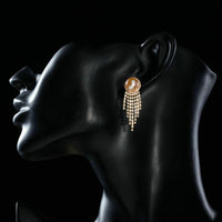 Side angle view of KHAISTA claw chain pearl earrings