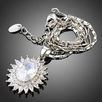 Side angle view of KHAISTA clear CZ sunflower necklace