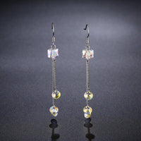 Side angle view of KHAISTA colour change raindrop dangle earrings