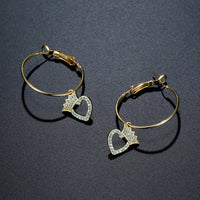 Side angle view of KHAISTA crown heart crystal dangle earrings