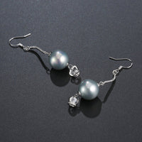 Close up of KHAISTA crown pearl drop earrings