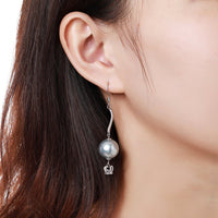 Side angle view of KHAISTA crown pearl drop earrings