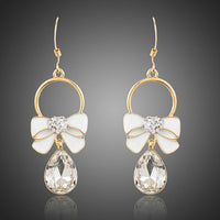 KHAISTA crystal bow knot drop earrings on white background