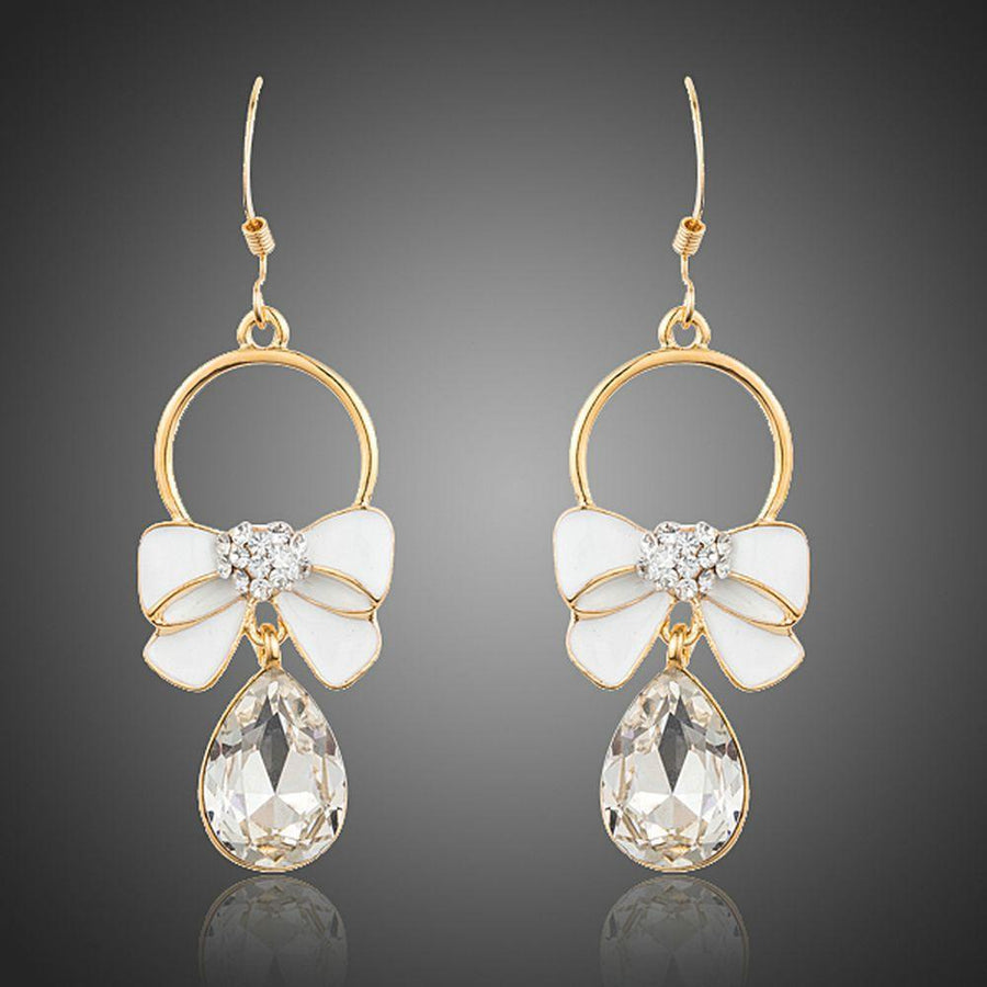 KHAISTA crystal bow knot drop earrings on white background