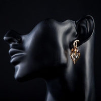 Side angle view of KHAISTA caramel crystal heart drop earrings