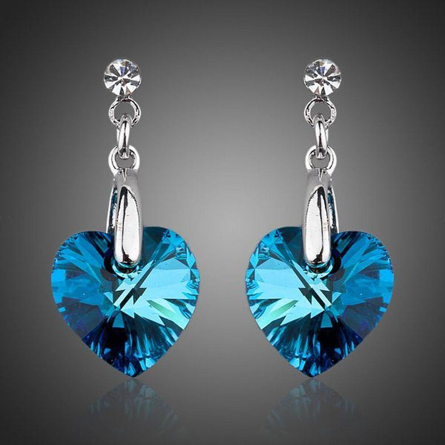 KHAISTA dark blue crystal heart drop earrings on white background