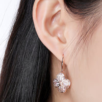 Close up of KHAISTA crystal flower drop earrings