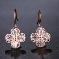 Side angle view of KHAISTA crystal flower drop earrings